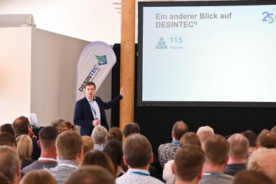Eine Person steht vor einem Publikum und hält einen Vortrag.